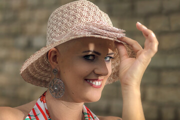 Portrait Mature woman, beautiful and strong fight against breast cancer disease. wearing a hat with joy and a mysterious look. Shows will to live and joy to fight.