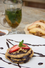 Apple pancake with chocolate sauce and strawberries with tea