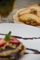 Apple pancake with chocolate sauce and strawberries with tea