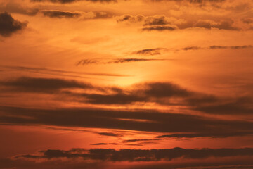 Clouds and atmosphere in warm evening colors with the sun behind the clouds