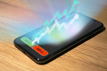 Stock Trading on a smartphone with chart and analysis as holograph over the display, Broker,...