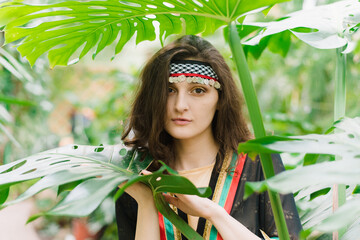 The girl from Jordan on the background of plants and palm leaves. Jordanian girl in the national...
