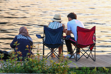 selective focus, people enjoying the view with camping chair by the sea