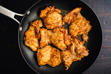 Browned Chicken Thighs with Spanish Seasonings in a Skillet: Browned chicken thighs and rice with smoked paprika, garlic, and other spices