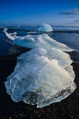 The last moments of melting icebergs on the beach next to the famous Jökulsárlón glacial lagoon,...