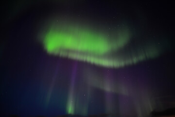 The green and purple dancing northern lights of the Aurora Borealis above Landmannalaugar, Fjallabak Nature Reserve, Iceland