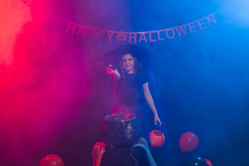 Funny child girl in witch costume for Halloween with pumpkin Jack.