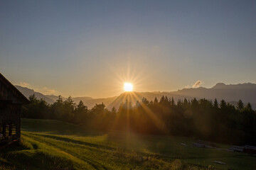 sunset over the triglav mountain with forest and meadow