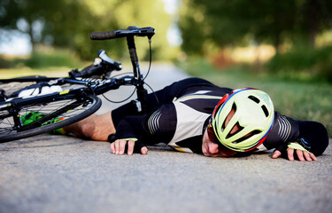 Exhausted cyclist lying down on the road. Sport and recreation concept