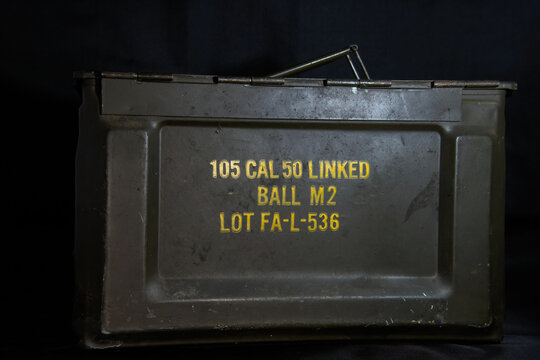 World War II vintage allied green metal ammunition box for 50 cal linked rounds, black background