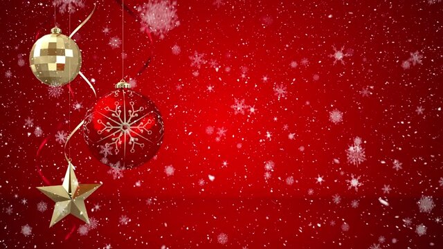 Animation of snow falling over red and gold christmas baubles decoration