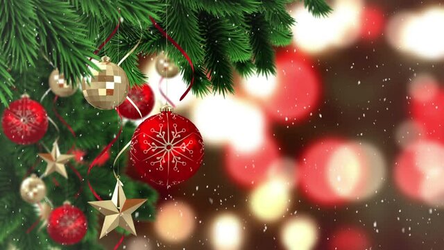 Animation of snow falling over red and gold christmas baubles decoration