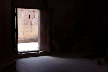 Fototapeta na wymiar Light entering through an open door into a church