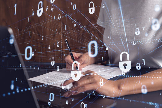 A businesswoman in casual wear signing the contract to prevent probability of risks in cyber security. Padlock Hologram icons over the working desk.