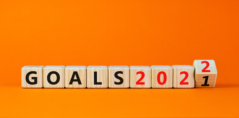 Planning 2022 goals new year symbol. Turned a wooden cube and changed words 'Goals 2021' to 'Goals 2022'. Beautiful orange background, copy space. Business, 2022 goals new year concept.