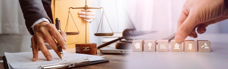 Justice and law concept.Male judge in a courtroom with the gavel, working with, computer and docking keyboard, eyeglasses, on table in morning light © ARMMY PICCA