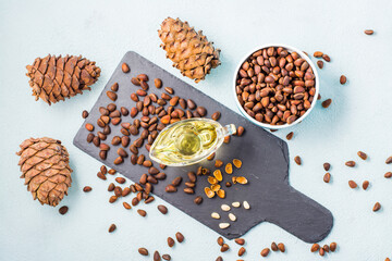 Fresh pine nut oil, nuts in a bowl and on a slate board. Remedy for insomnia and detox food....