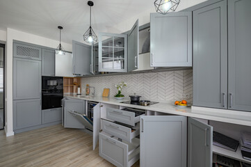 Trendy grey and white modern kitchen furniture with doors open