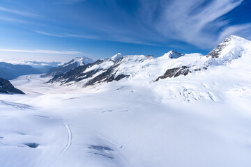 des montagnes enneigées sous un ciel bleu au bords d'un glacier