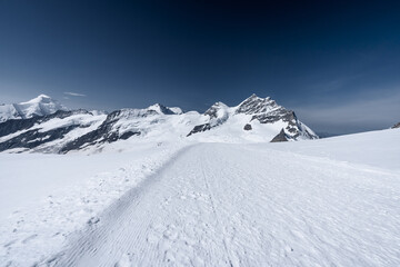 un chemin dans la neige en haute montagne - 452575801