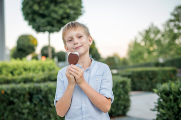 blonde boy in blue shirt eating popsicle ice cream