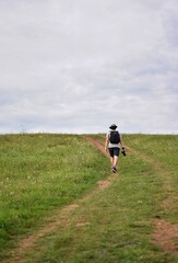 Fototapeta na wymiar male photographer walking across a green meadow