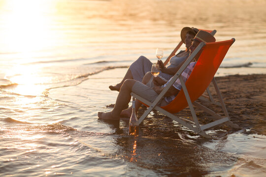 senior couple drink wine and spending time at the beach. 