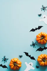 Foto op Plexiglas Happy halloween holiday concept. Frame of halloween decorations, bats, ghosts, pumpkins, spiders on blue background. Halloween party invitation card mockup with copy space. Flat lay, top view. © photoguns