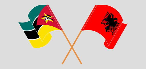 Crossed and waving flags of Mozambique and Albania