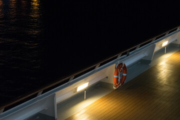 Lit deck of a boat with an emergency lifebuoy