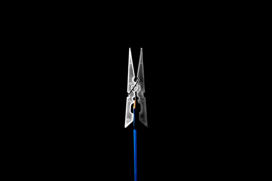 Pencil with pointed tip and pin on black background