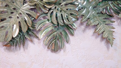 Beautiful texture for the design. Tropical monstera leaves made of iron on a pink textured background. Top view. A copy of the space for the text.