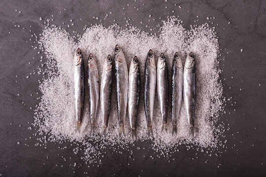 Fresh anchovies on table with salt