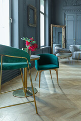 chic interior of the room in the Renaissance style of the 19th century with modern luxury furniture. walls of noble dark color are decorated with stucco and gilded frames, wooden parquet.