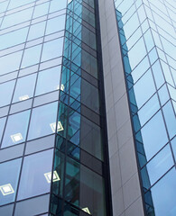 close up of a modern office building with geometric glass panels illuminated with square lights