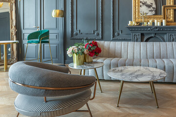 chic interior of the room in the Renaissance style of the 19th century with modern luxury furniture. walls of noble dark color are decorated with stucco and gilded frames, wooden parquet.