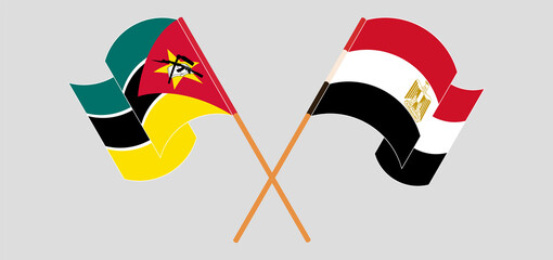 Crossed and waving flags of Mozambique and Egypt