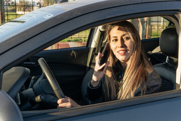 Latina blonde woman answering a cell phone call in a car. Concept of mobility, communication.