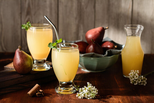 Glasses of cocktails with pear juice and elderflower leaves