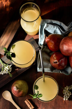 Glasses of cocktails with pear juice and elderflower leaves