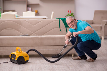 Fototapeta na wymiar Old man cleaning the house