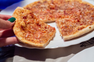 Woman catching a slice of barbecue flavor pizza.