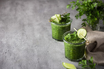 Freshly cooked parsley smoothie with cucumber on gray concrete background, selective focus, copy space. Homemade healthy food concept