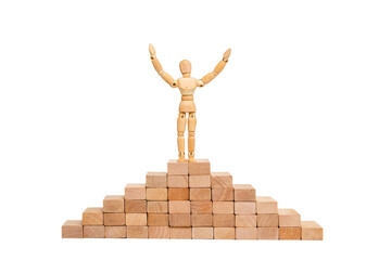 Champion. Wooden mannequin human figure raised hands up, stands on a wooden pedestal. Concept is success and a winner.