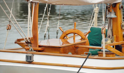 Expensive retro sailing boat (ketch) moored to a pier in a new yacht marina. Wooden teak deck, elegant details. Transportation, nautical vessel, vacations, tourism, cruising, regatta, recreation