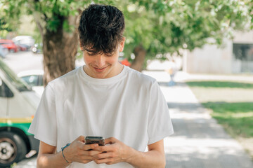 portrait of teenage boy with mobile phone in the street outdoors