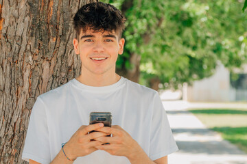 portrait of teenage boy with mobile phone in the street outdoors