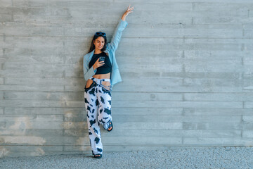 happy girl with mobile phone on the street wall with copy-space