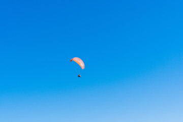 Paraglider flying over Saquarema beach, Rio de Janeiro. Sunny day with blue sky in the background