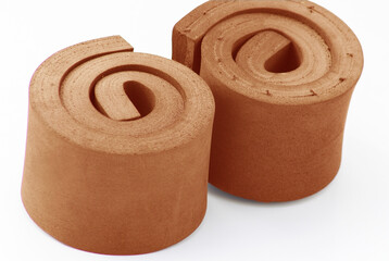 two rolls of orange foam material.  eva sponge foam isolated on white background. for bearings, impact resistors, dampers, craft, water resistance